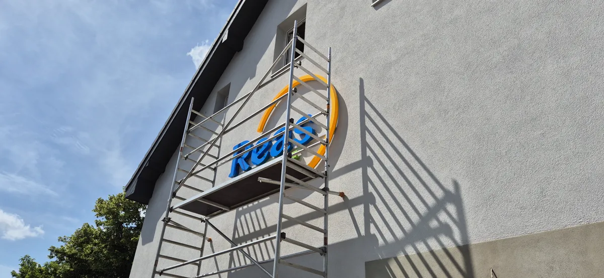 3D-Logo aus Einzelbuchstaben an einer Hausfassade